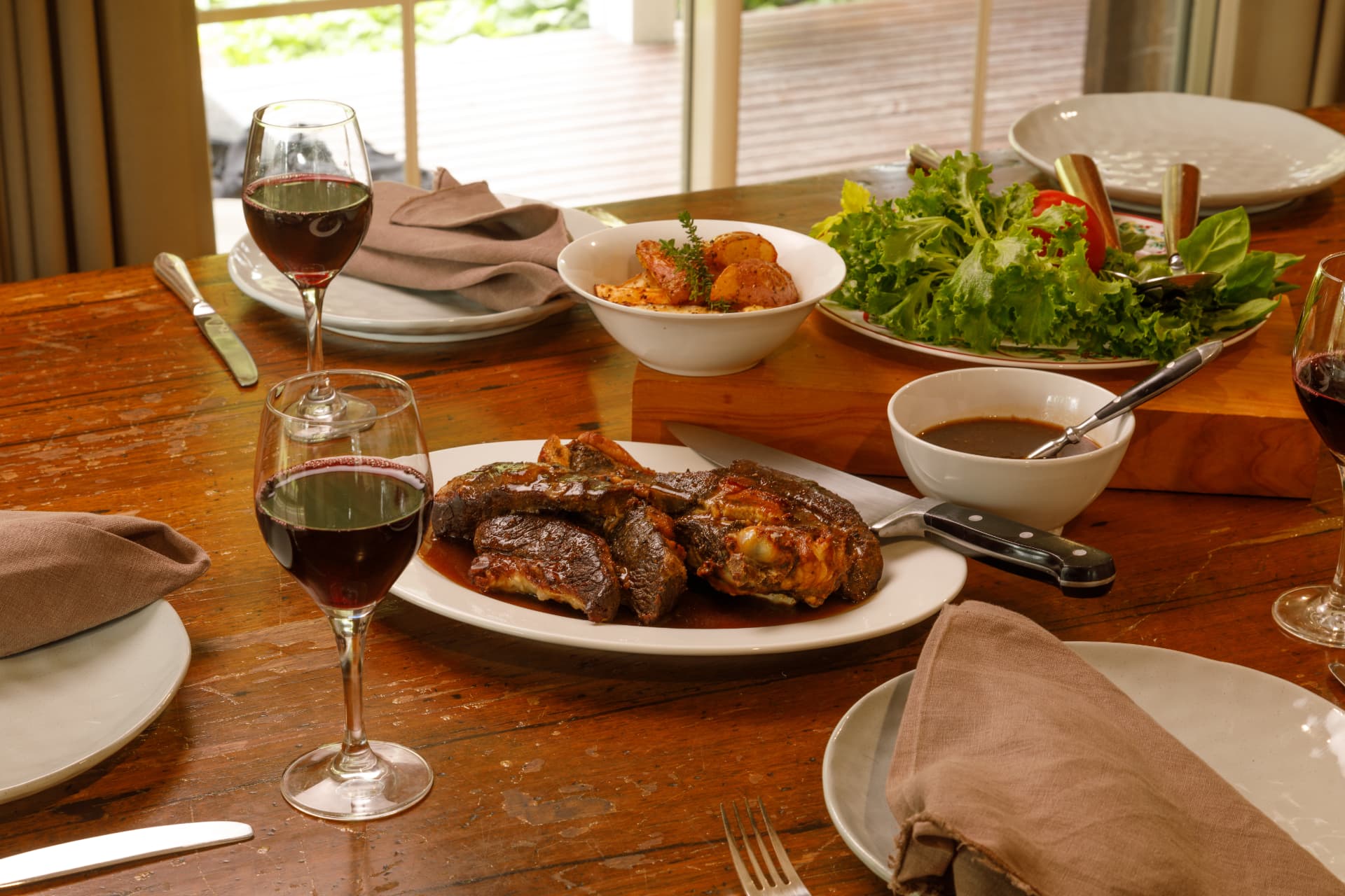 Shared banquet table with roast lamb and red wine
